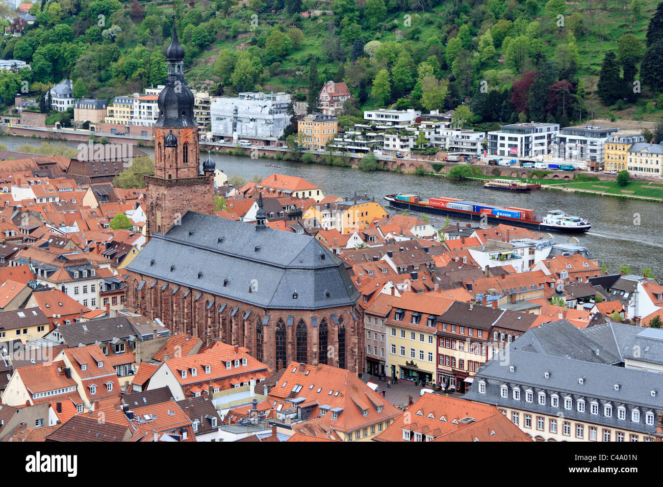 The church of Heiliggeist-Kirche Heidelberg, Germany with a barge transporting freight on the River Neckar Stock Photo