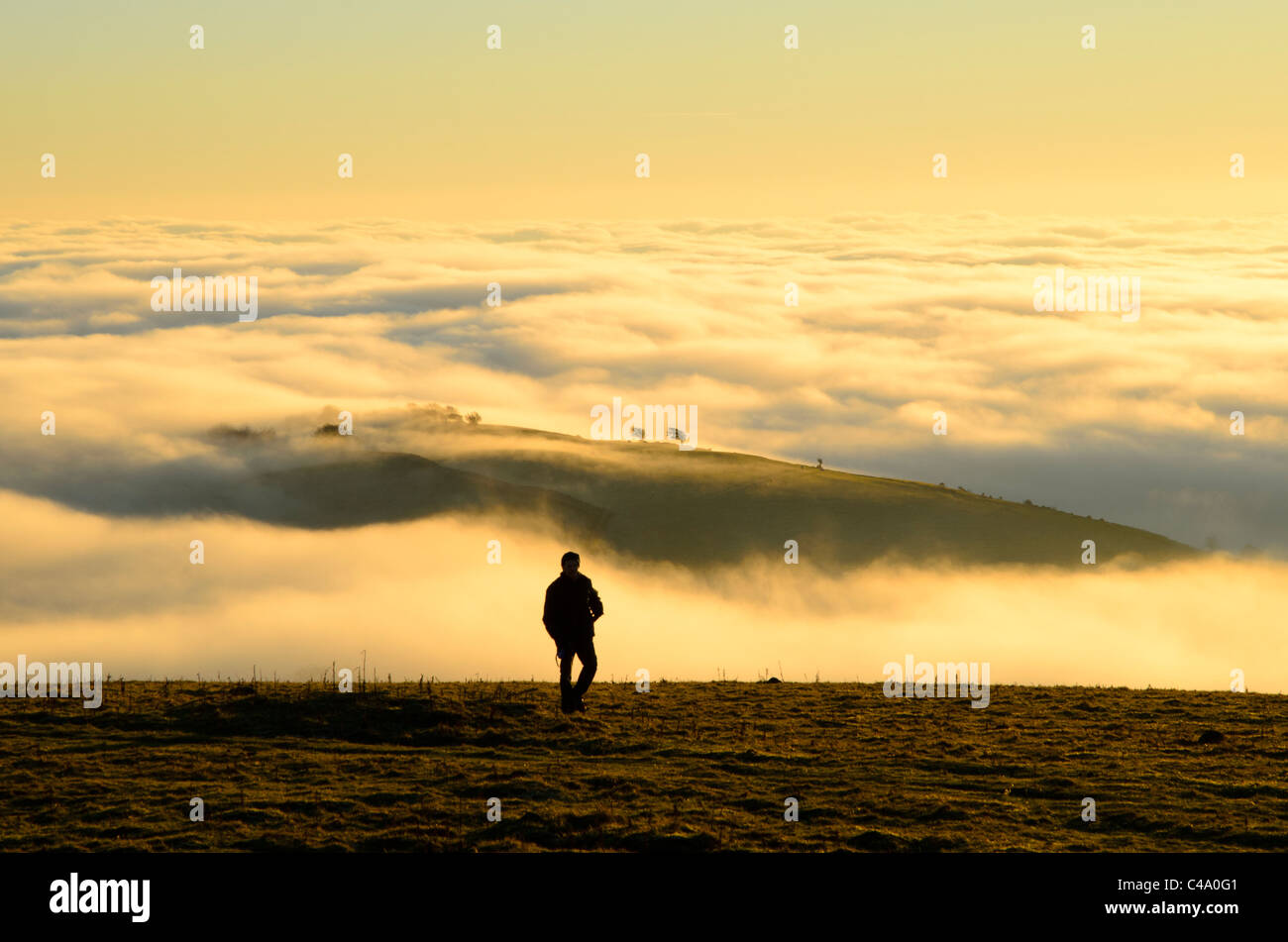 Walker in evening above cloud inversion on Hampsfell near Grange-over-Sands, Cumbria Stock Photo