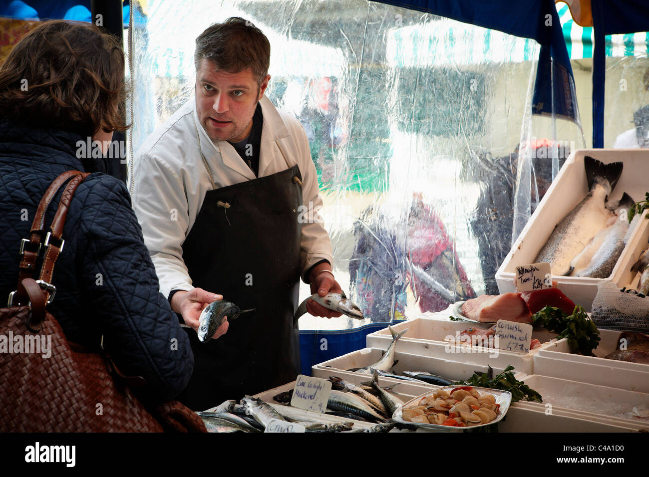A traditional fishmonger sellsing fish from his market stall in London ...