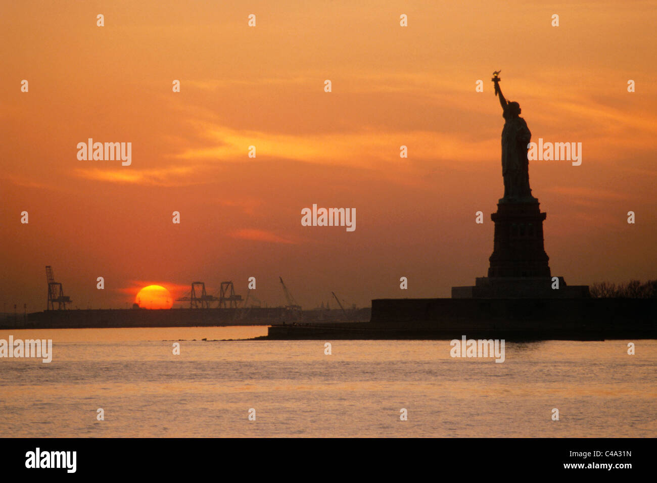 Photograph of the Statue of Liberty in New York at sunset Stock Photo