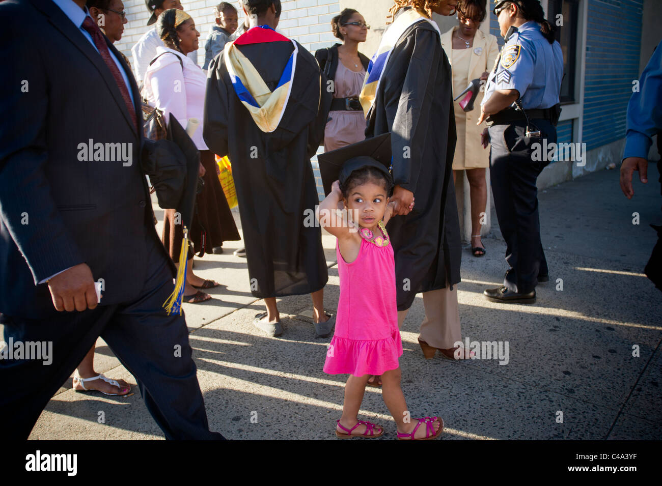 Graduates and their families and friends outside after John Jay College commencement in New York Stock Photo