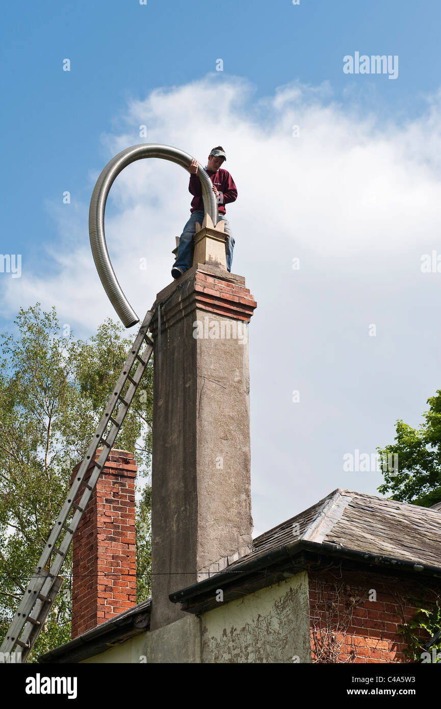 Inserting a flexible chimney liner into an old chimney, UK Stock Photo