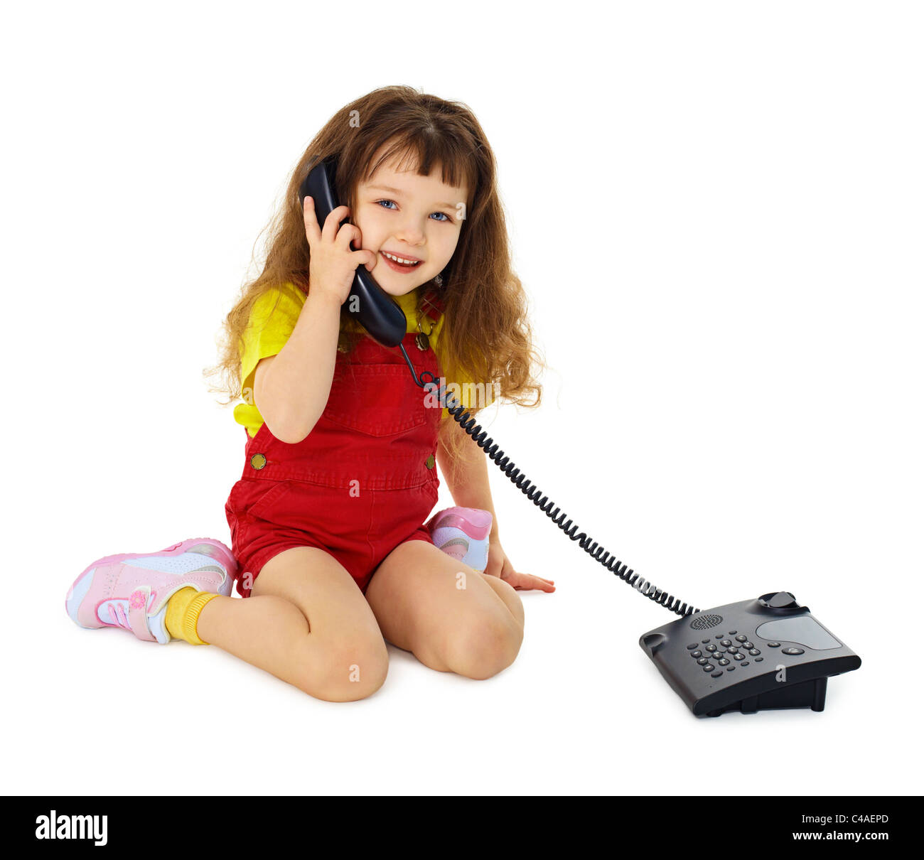 Little girl talking on the phone isolated on white background Stock Photo