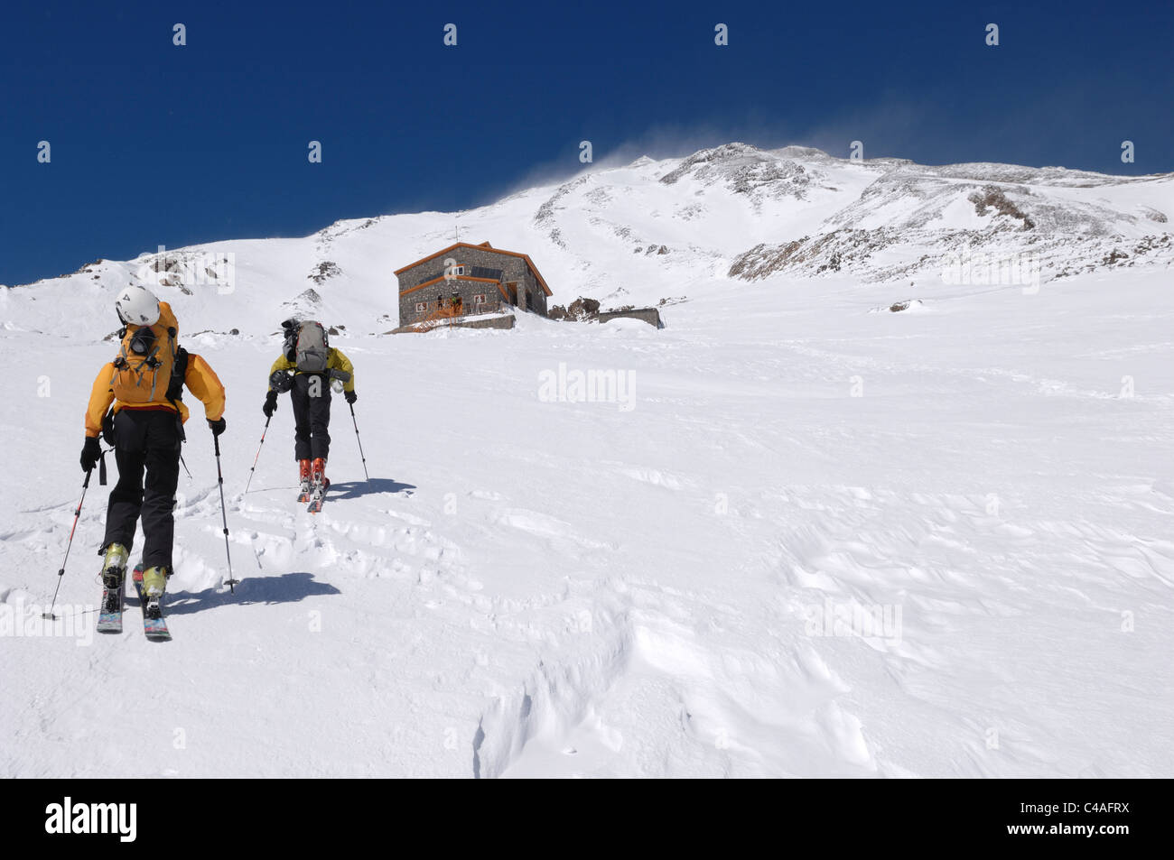 A man skinning up hill while ski mountaineering at altitude on Mount Damavand a volcano in the Alborz mountains Iran Stock Photo