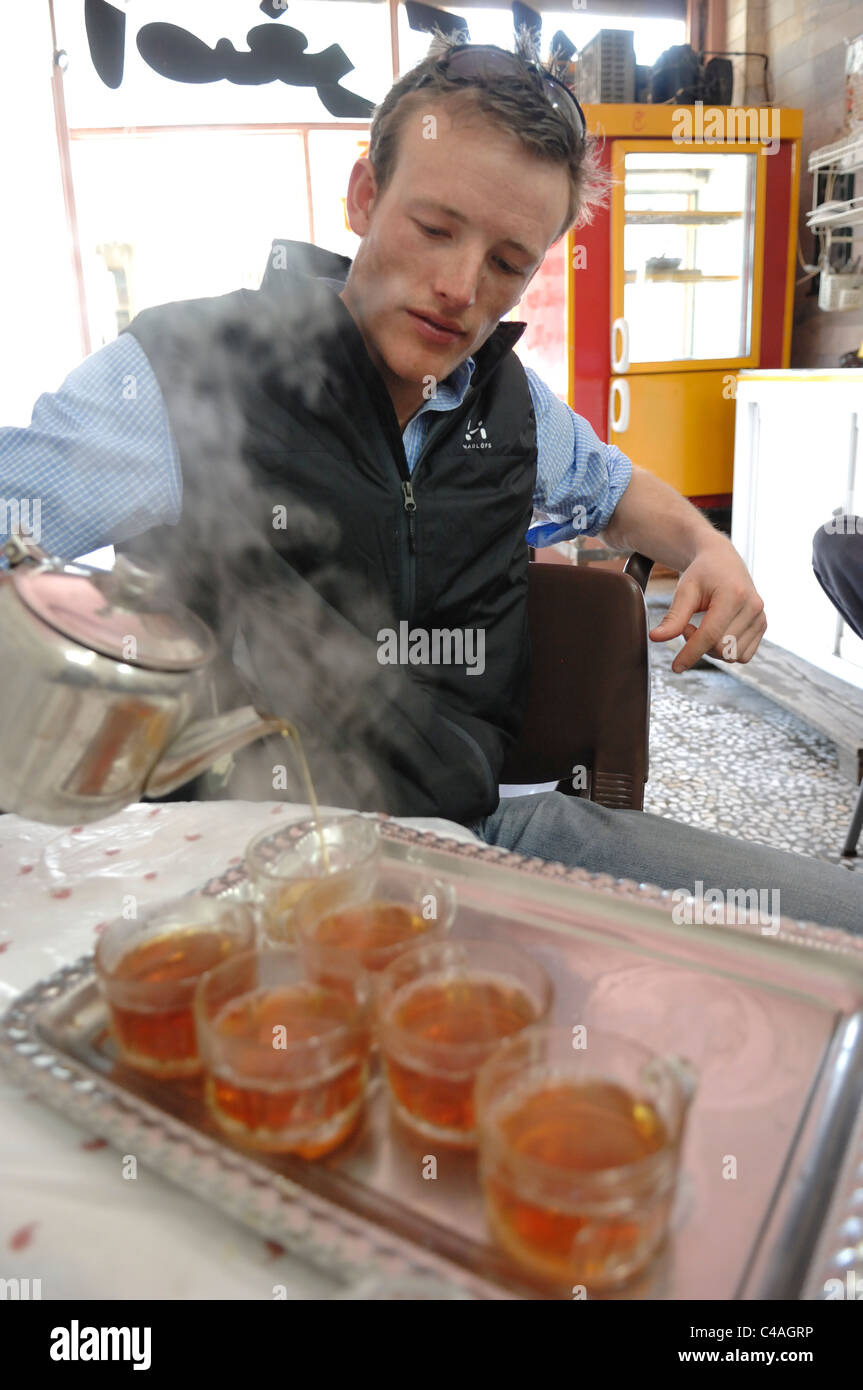 A Caucasian man pouring tea in a traditional Iranian tea house shop in Larijan a small village in the Alborz mountains. Stock Photo