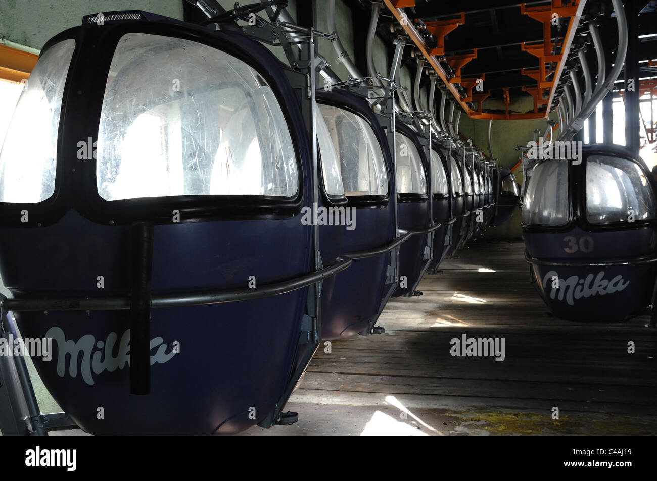 Ski lift cabins or gondolas racked up in the lift station in Dizin with an advertisers Milka logo on them Stock Photo