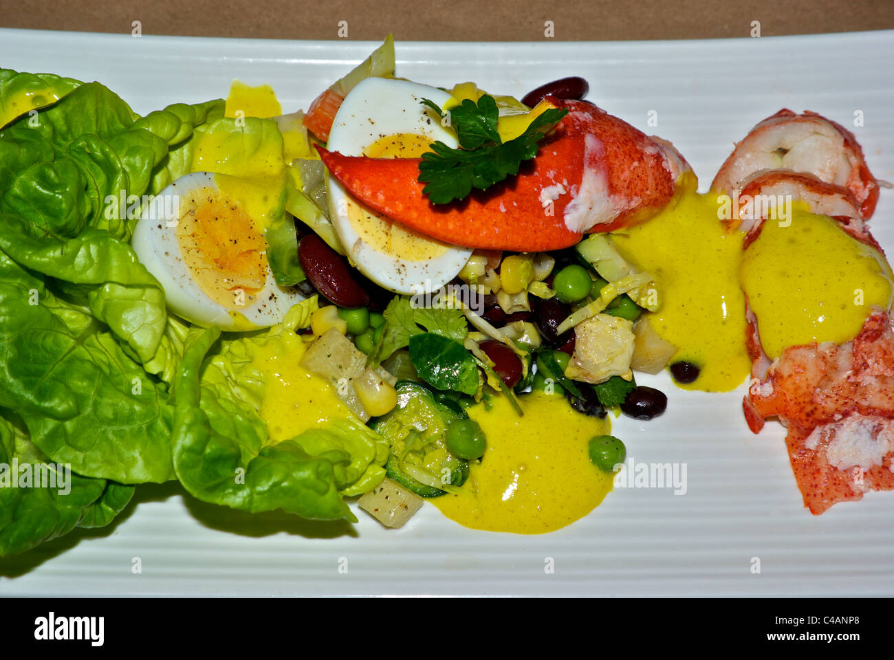 Lobster meat salad hard cooked egg mixed greens peas corn Stock Photo