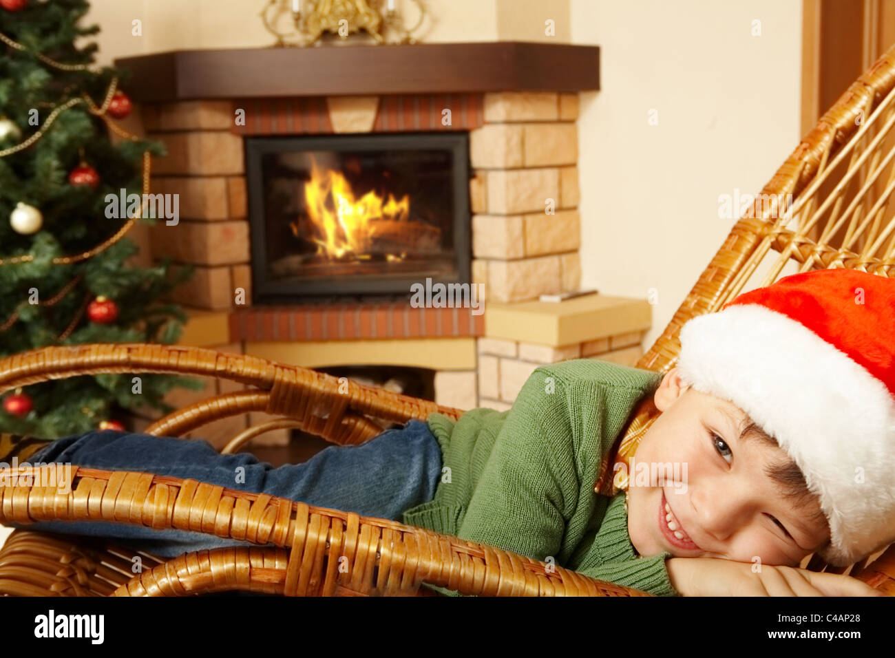 Photo of cute boy wearing santa cap pretending to sleep in rocking