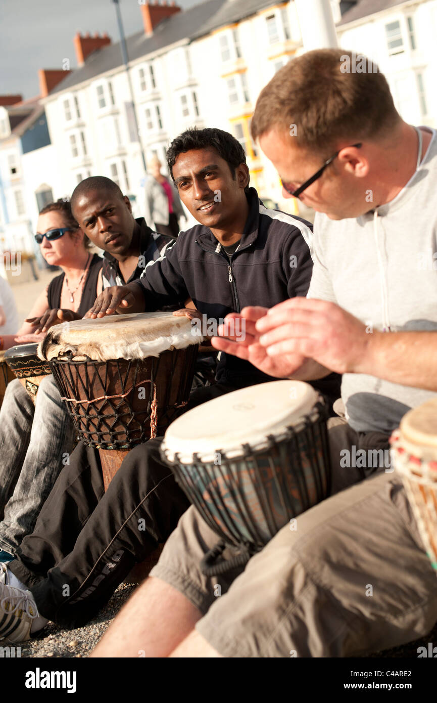 A mixed ethnic group of men taking part in an impromptu drumming