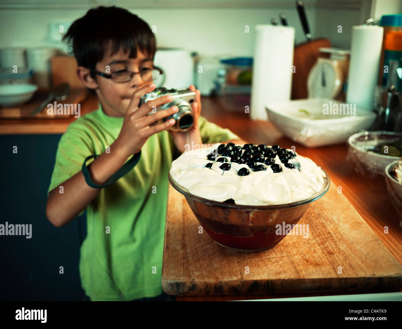 Boy takes picture of homemade trifle. Stock Photo