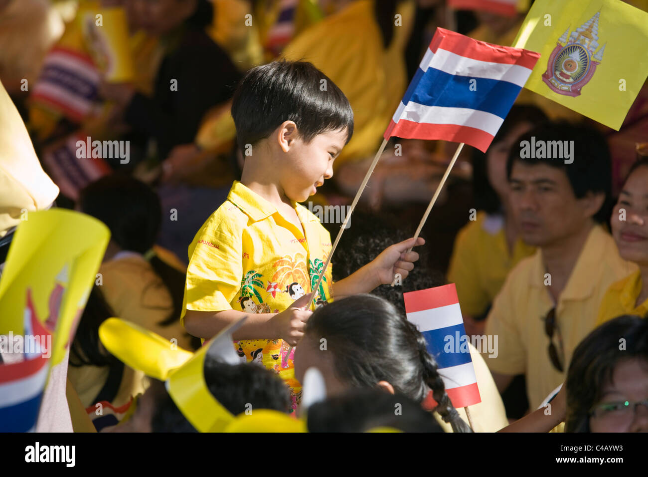 Thailand, Bangkok.  Young boy helping celebrate King Bhumibol Adulyadej's 80th birthday.  Supporters dress in yellow Stock Photo