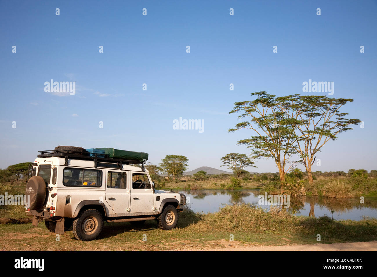 Tanzania, Serengeti. A Land Rover stops by the Seronera hippo pool. Stock Photo