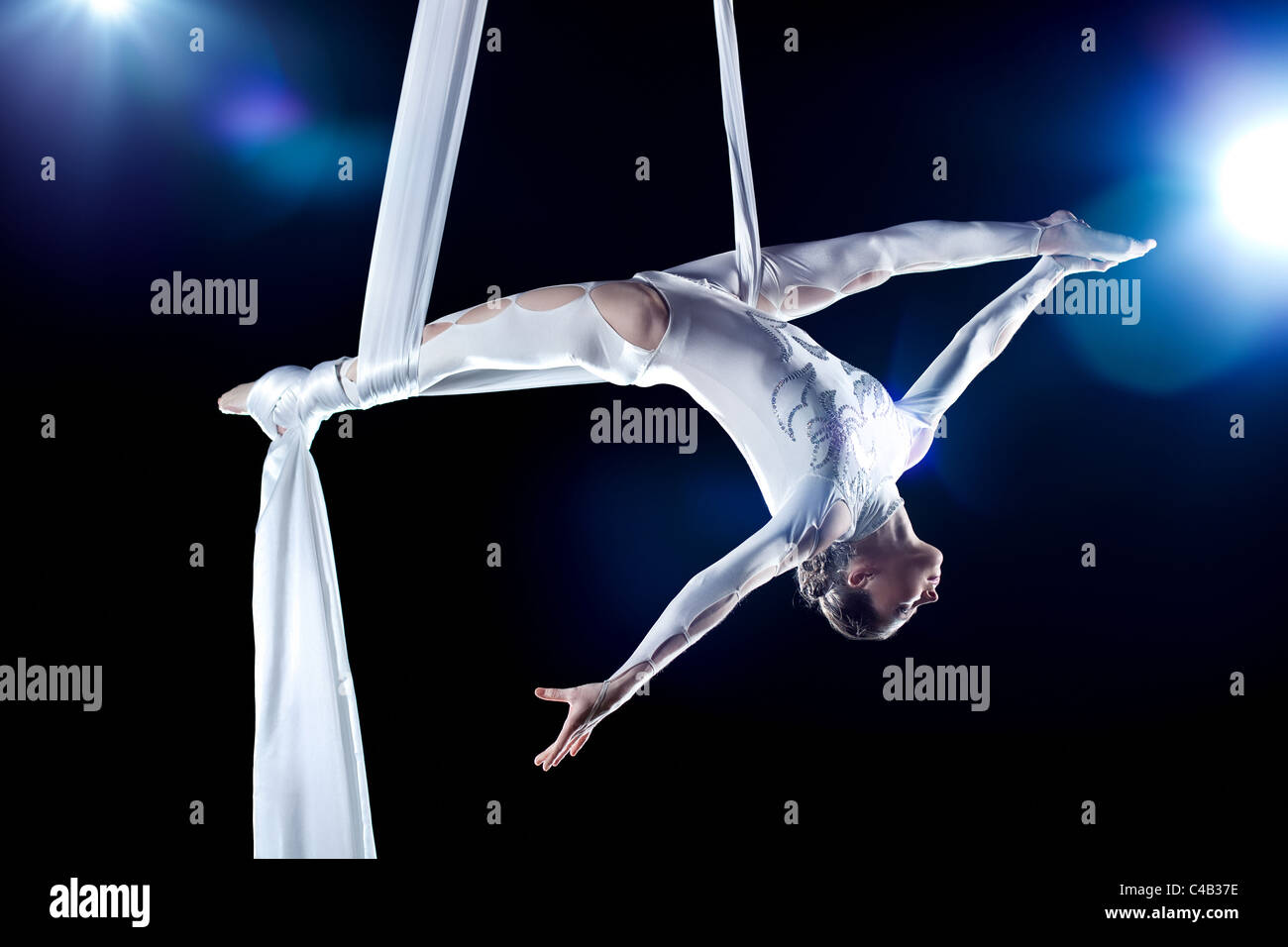 Young woman gymnast. On black background with flash effect. Stock Photo