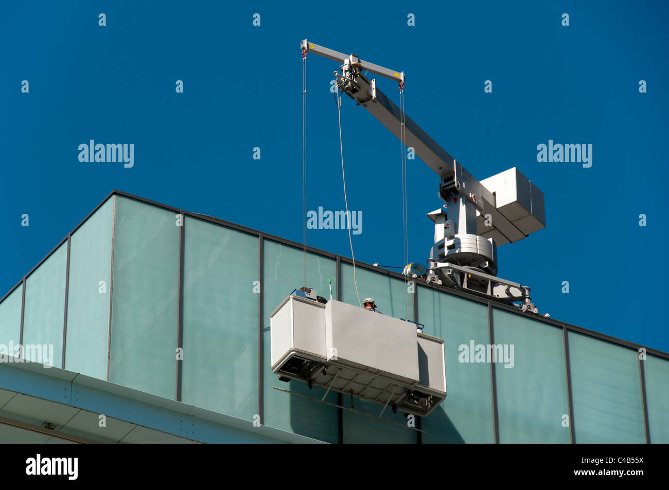 Workers on a suspended access platform at the MediaCityUK complex, Salford Quays, Manchester, England, UK Stock Photo