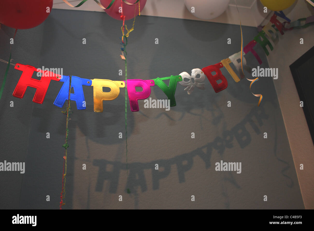 A celebration with a Happy Birthday banner sign hanging on the ceiling; perfect for a childs birthday party. Stock Photo