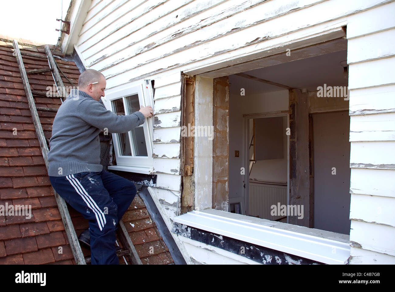 Installing A rated energy efficient replacement double glazed windows on an old house Stock Photo