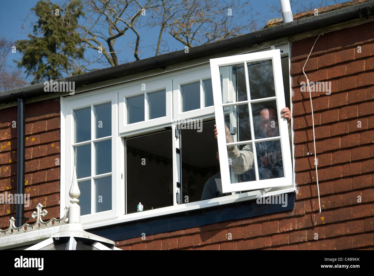 Installing A rated energy efficient replacement double glazed windows on an old house to improve energy efficiency Stock Photo