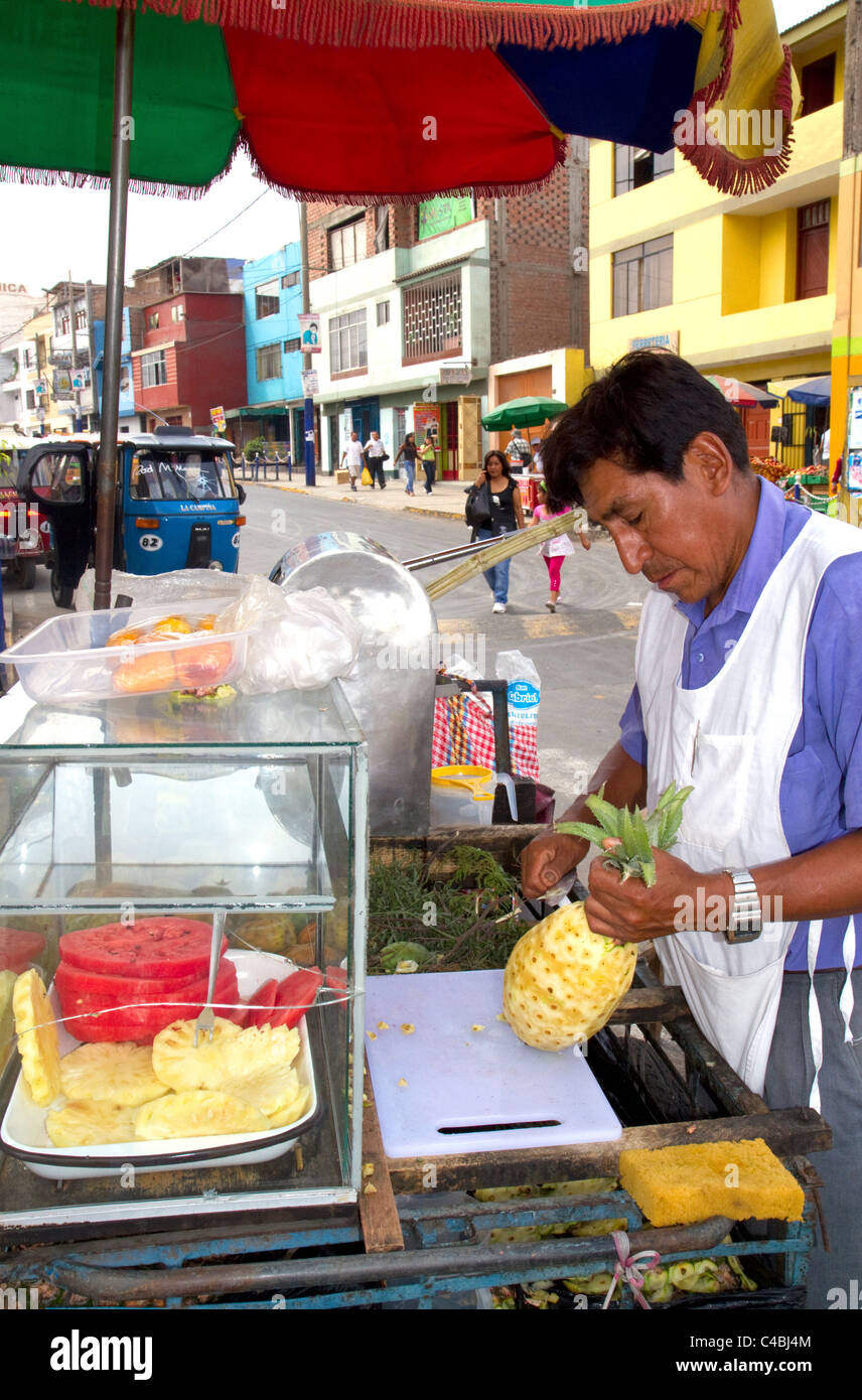 Street vendor carving a pineapple in Lima, Peru. Stock Photo