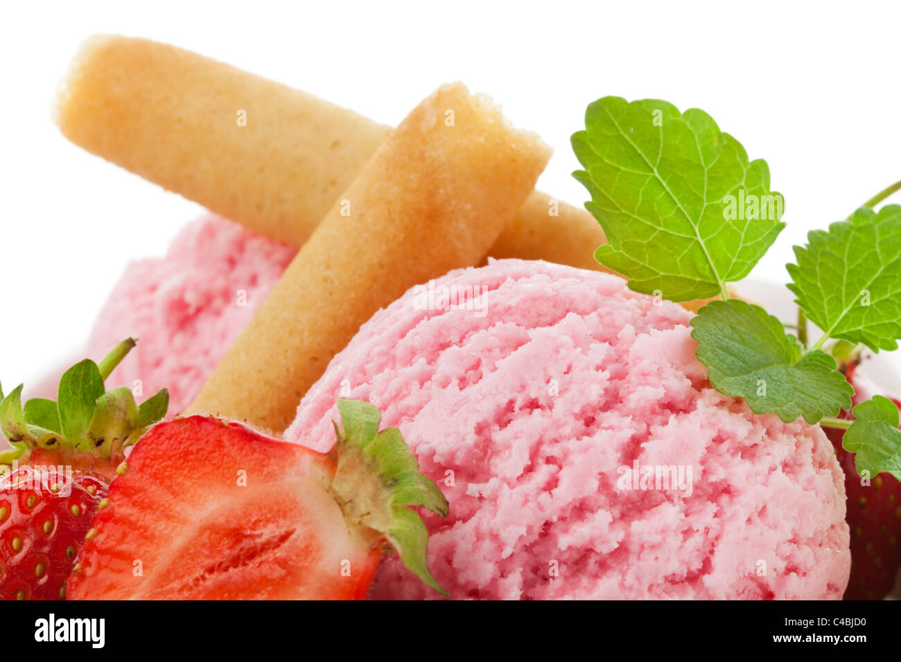 close-up of strawberry ice cream scoops with fruit, waffles and mint leaves Stock Photo