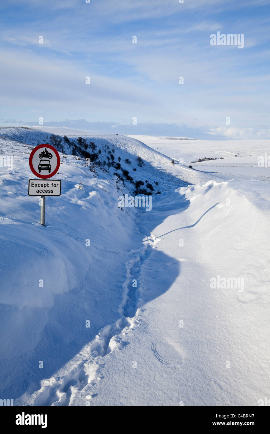 'No motor vehicles' road sign on North York Moors on clearly impassable road across the moors in severe winter conditions Stock Photo