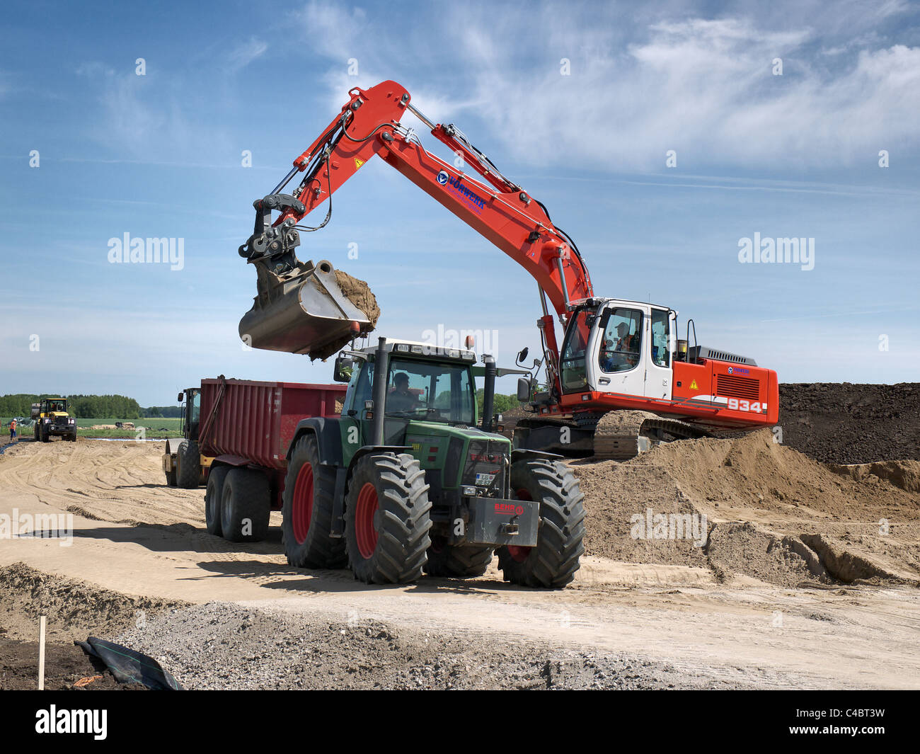 Shovel excavator loading a dump lorry with earth on a building site near Tespe, Lower Saxony, Germany Stock Photo