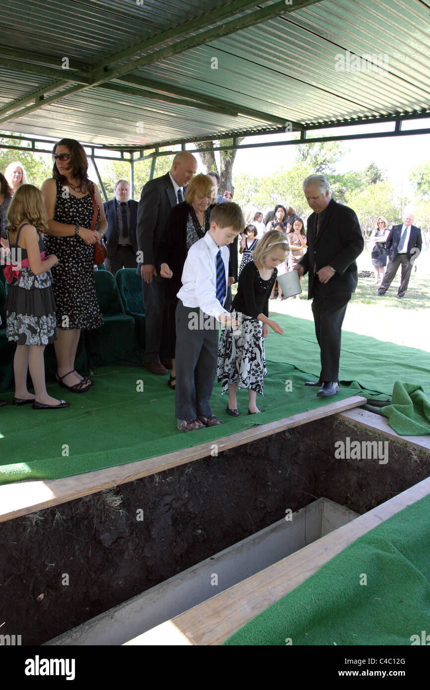 Children throwing soil onto coffin at Family burial in Texas USA Stock Photo Alamy
