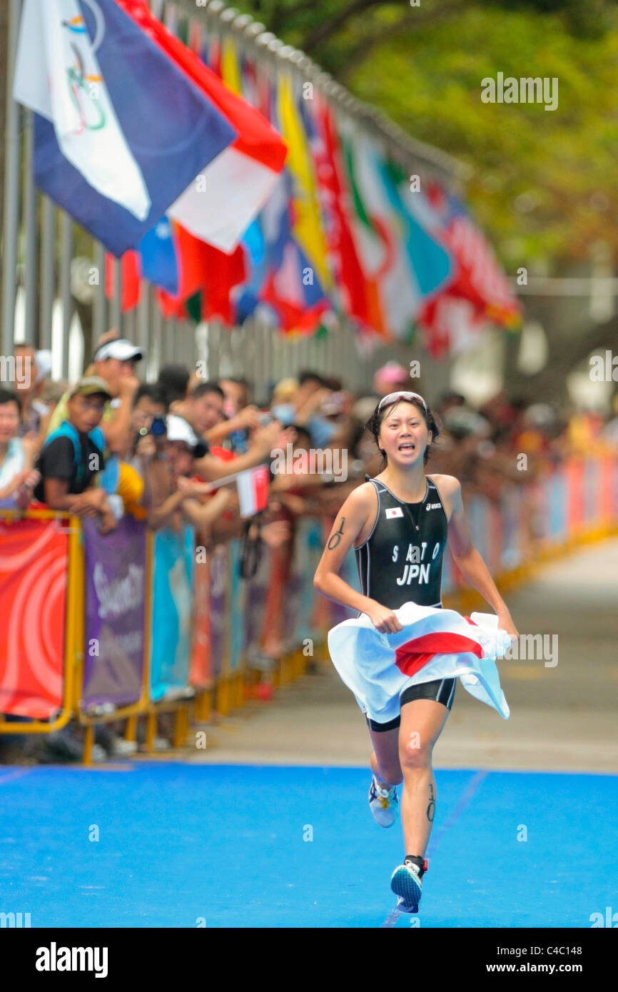 YOG Women's Triathlon champion, Sato Yuka(JPN), runs with her nation's flag as she nears the finishing line. Stock Photo