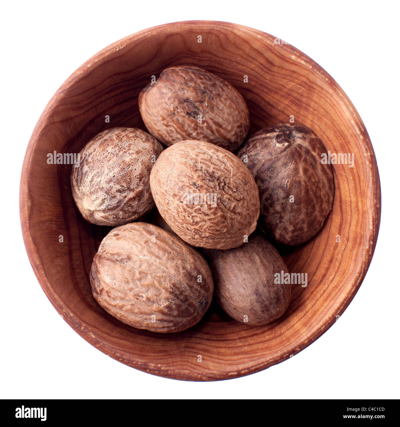 Nutmeg in a wooden bowl isolated on white Stock Photo
