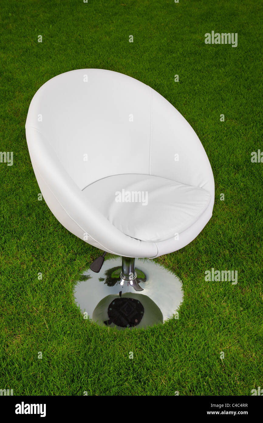 stylish white design leather swivel chair on green grass Stock Photo