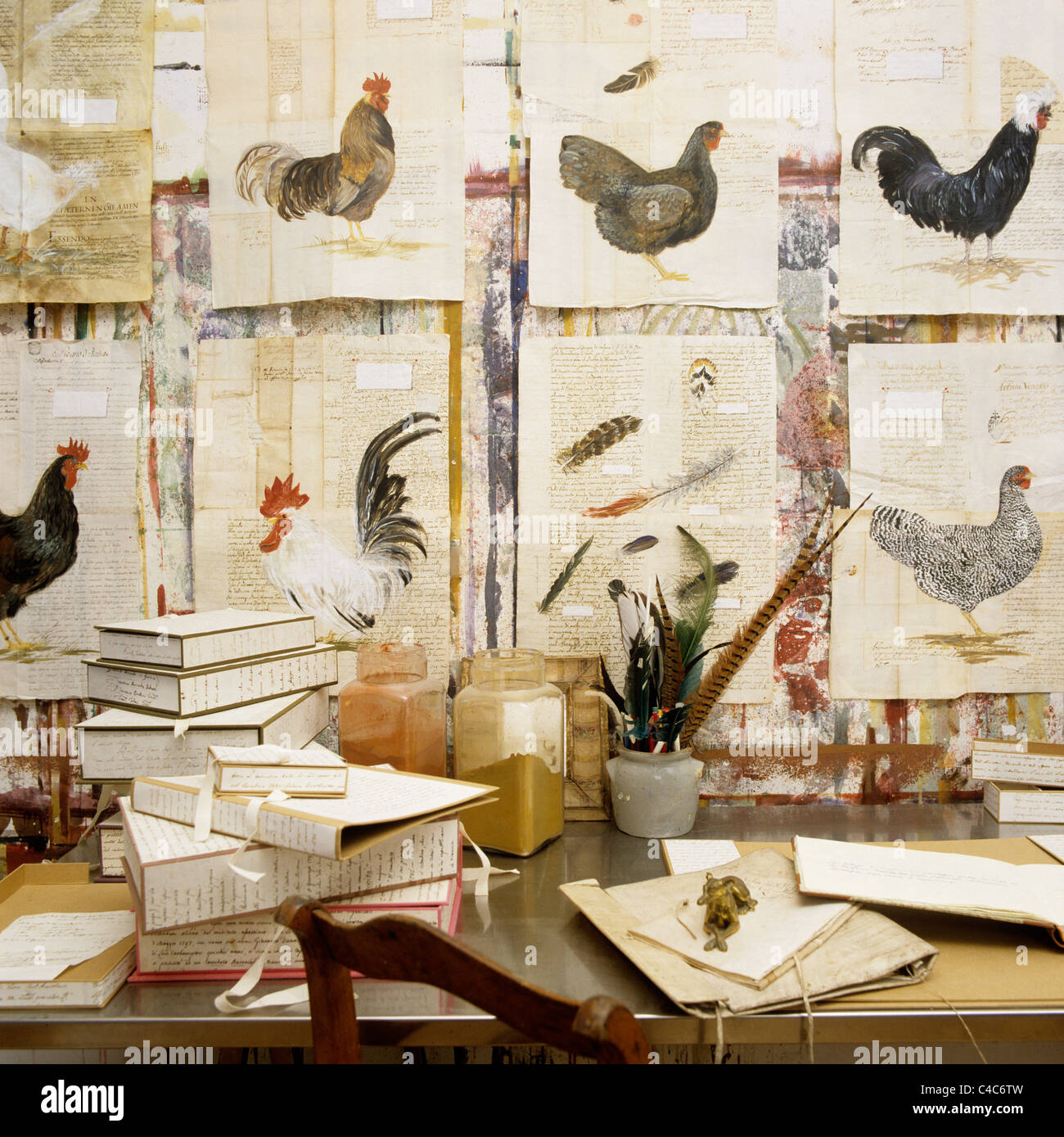 Row of watercolour hens on wall above artists table Stock Photo