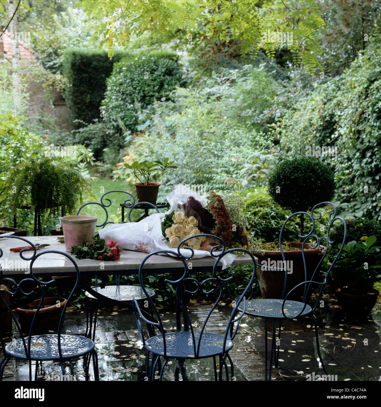 Outdoor wrought iron furniture on wet terrace of garden Stock Photo Alamy