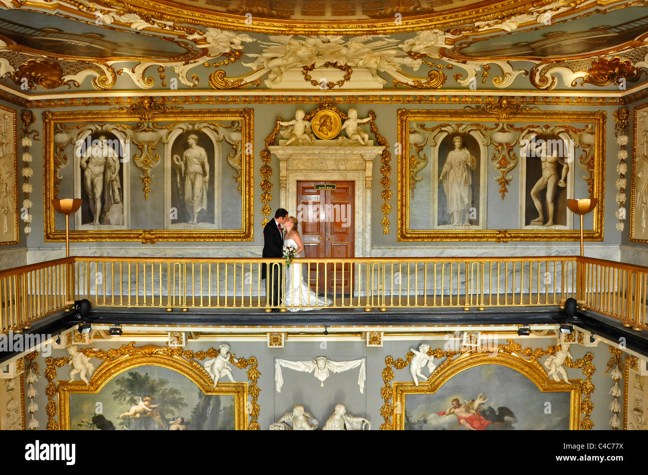 Bride and Groom kissing on balcony in colorful highly decorated historic room at Moor Park country club Stock Photo