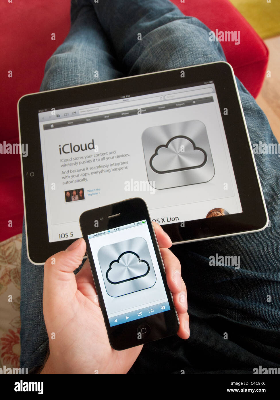 iCloud cloud computing service icon on an iPhone 4G smart phone screen with Apple website on iPad Stock Photo
