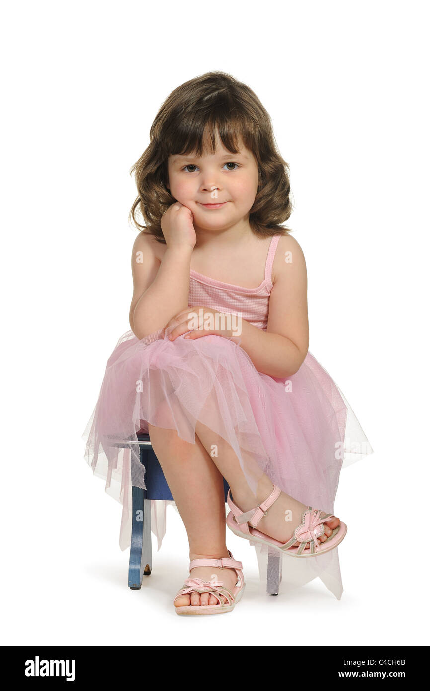 Pretty the little girl sits on a stool. It is isolated on a white background Stock Photo Alamy