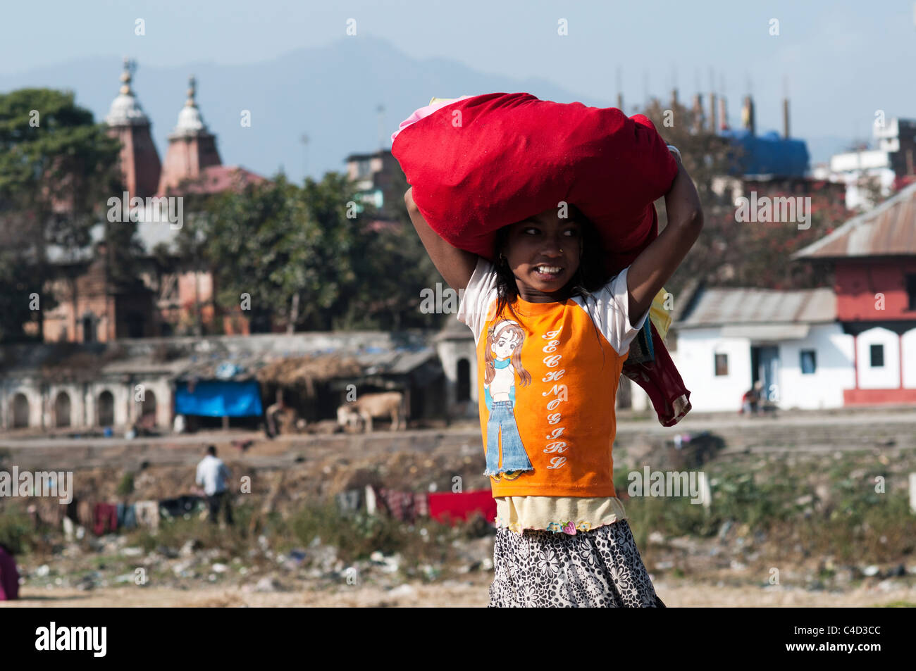 A Nepali girl washing her clothes in the dirty Bagmati river. Stock Photo