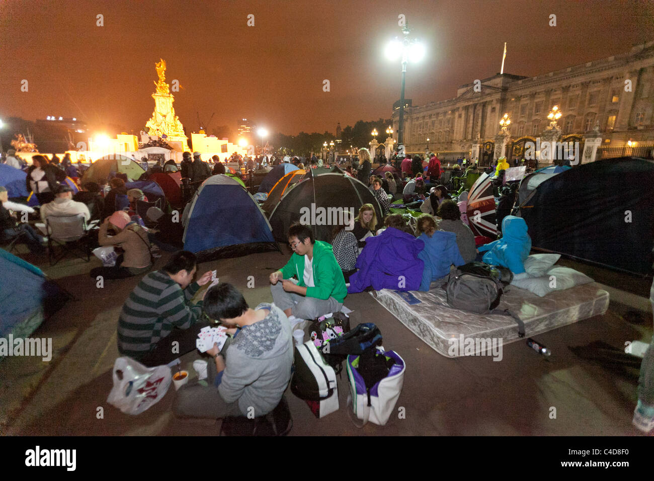 Festive crowds camping out in front of Buckingham Palace the night before the royal wedding of Prince William and Kate Middleton Stock Photo
