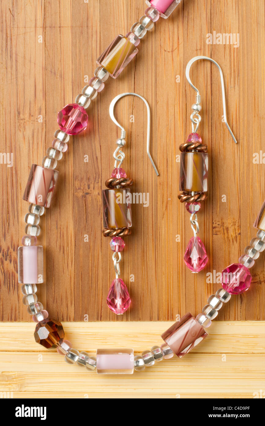 Shown here some homemade jewelry displayed on a bamboo board. Stock Photo