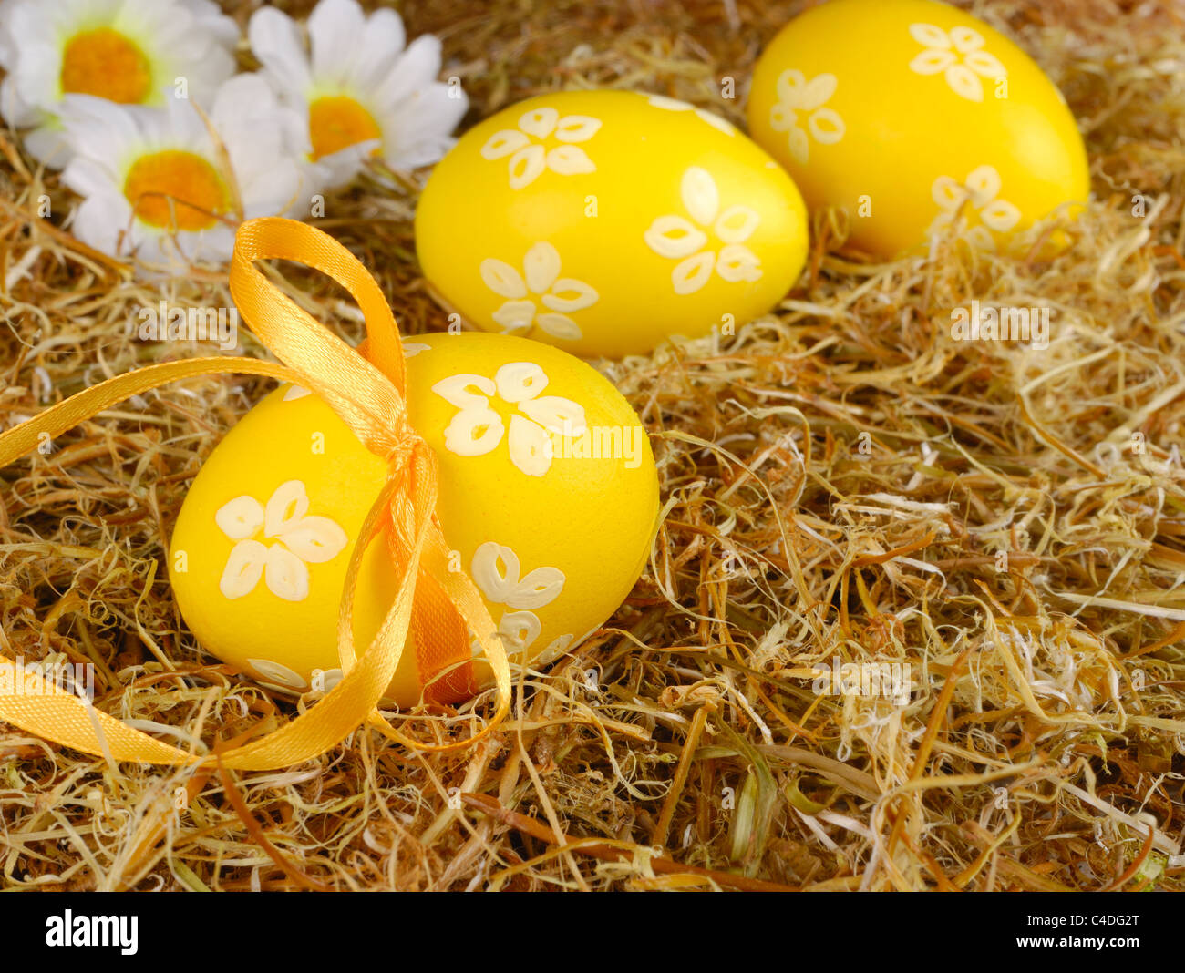 Yellow easter eggs in the basket over hay background Stock Photo