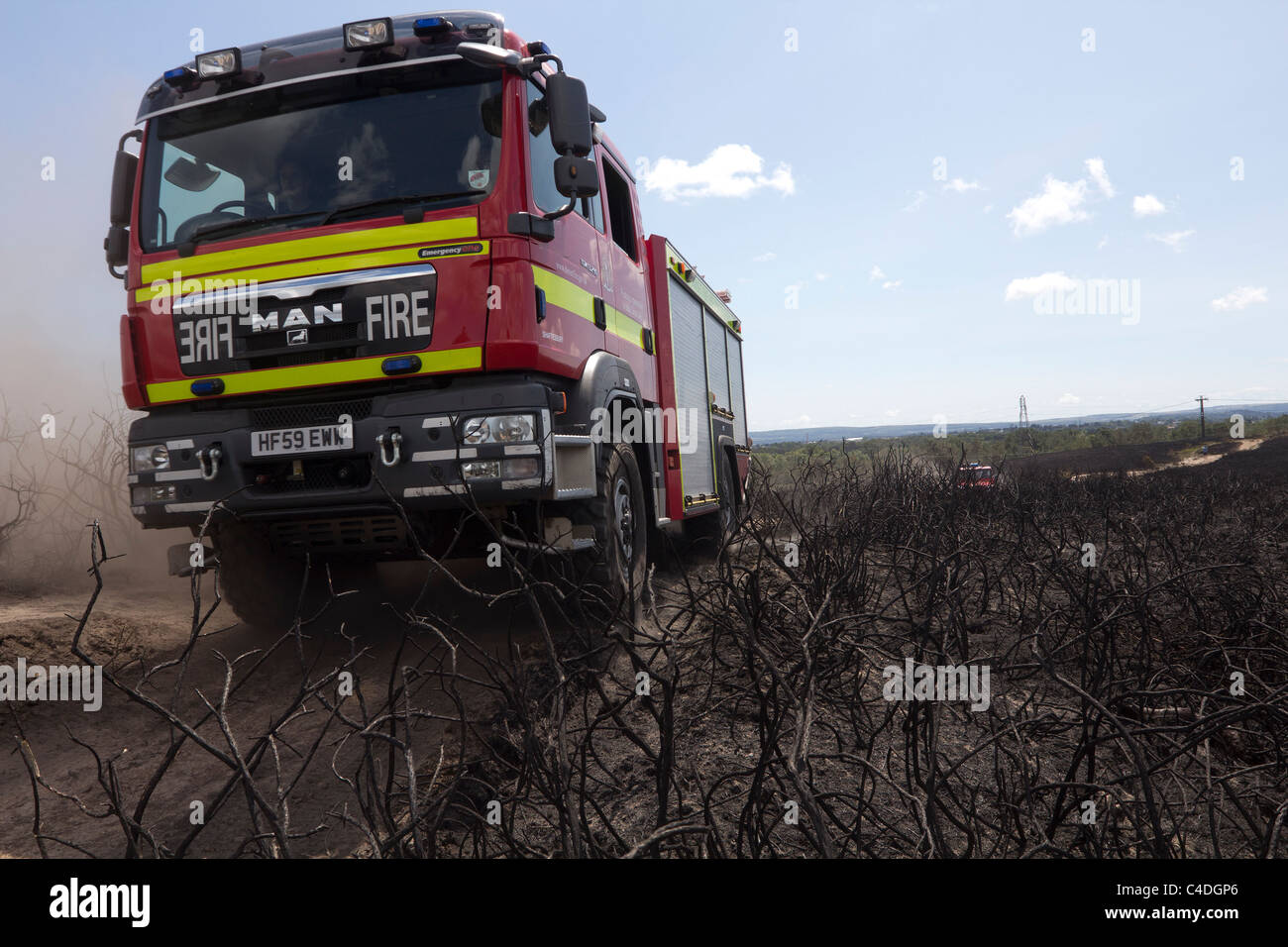 Fire engine crosses burnt heathland. Stock Photo