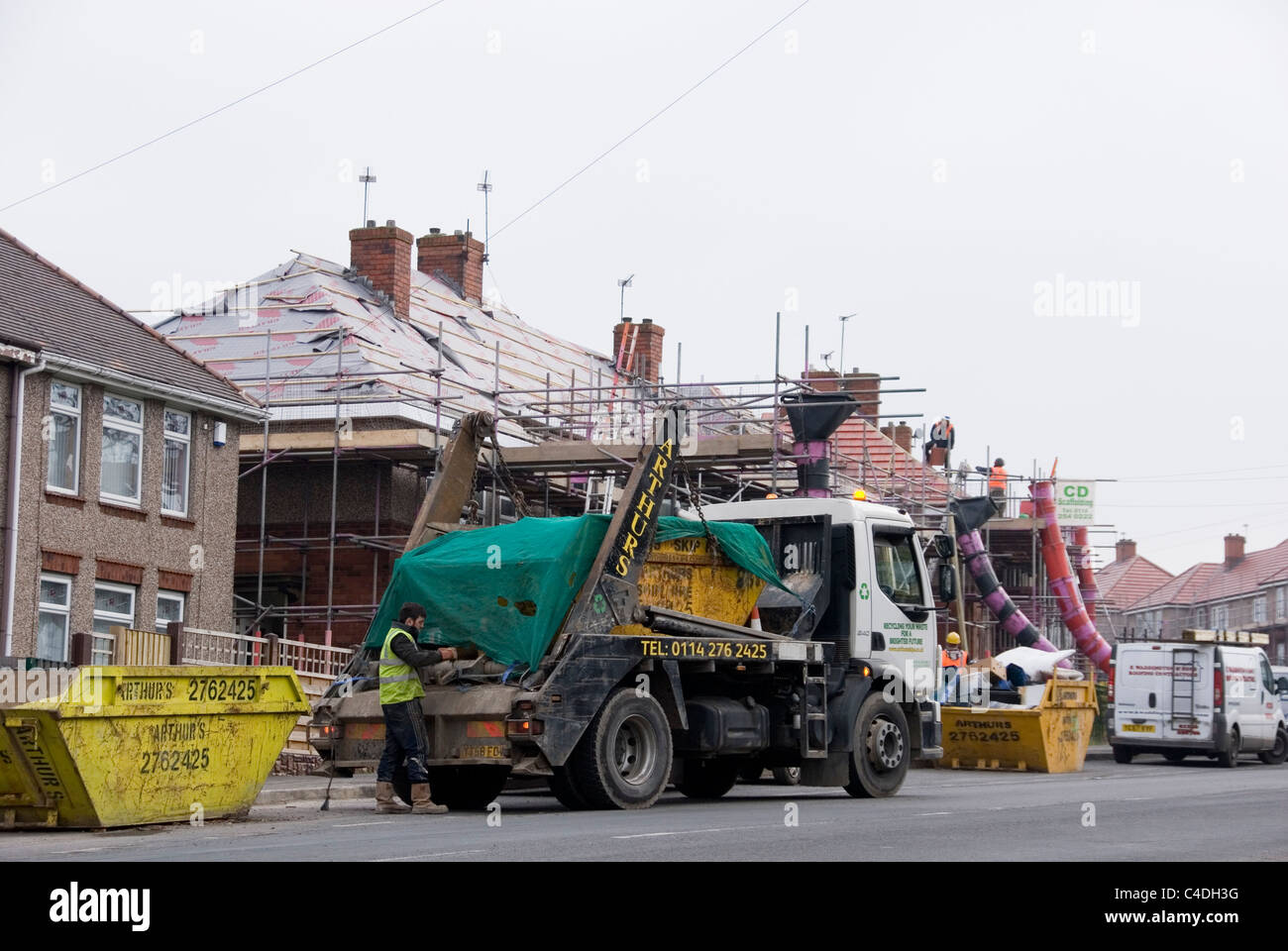 Driver of Skip Lorry Collecting Full Skip, Re Roofing ACIS Properties, Hastilar Road South, Sheffield, March 2011 Stock Photo