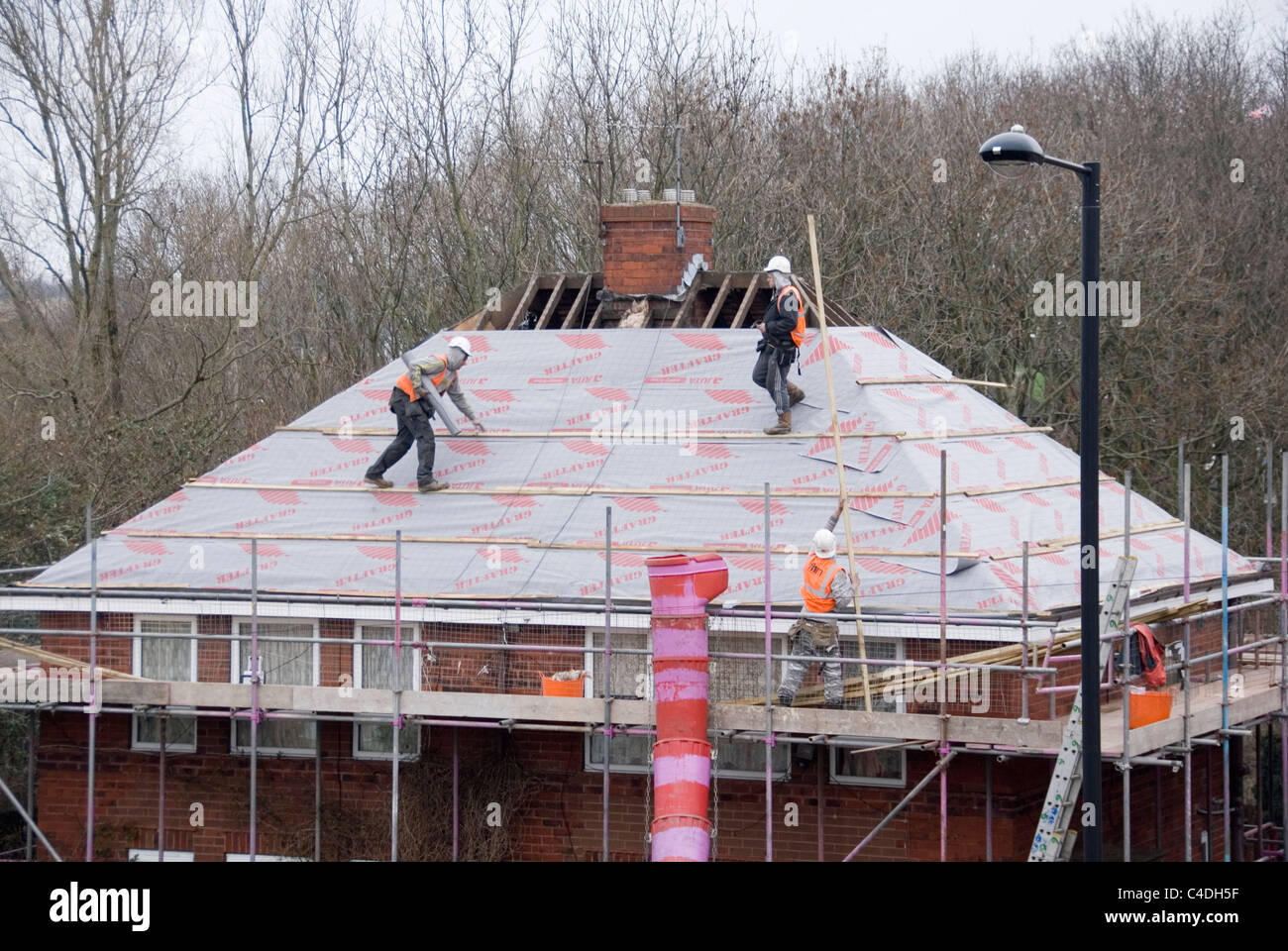 Two Men Wrapping Roof of House with Breathable Roofing Felt, Re Roofing ACIS Properties, Hastilar Road South, Sheffield, 2011 Stock Photo