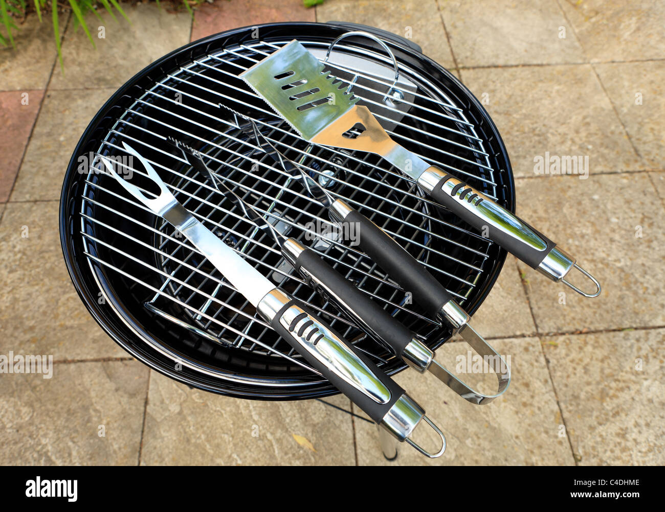 a traditional style bbq with tools placed on it brand new and unlit Stock Photo