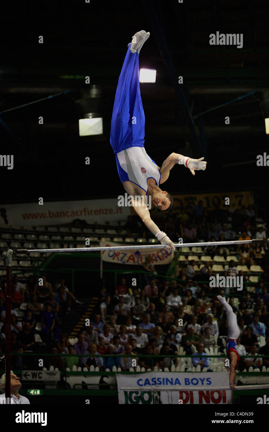 gymnastics competition: a gymnast's performing his high bar routine Stock Photo