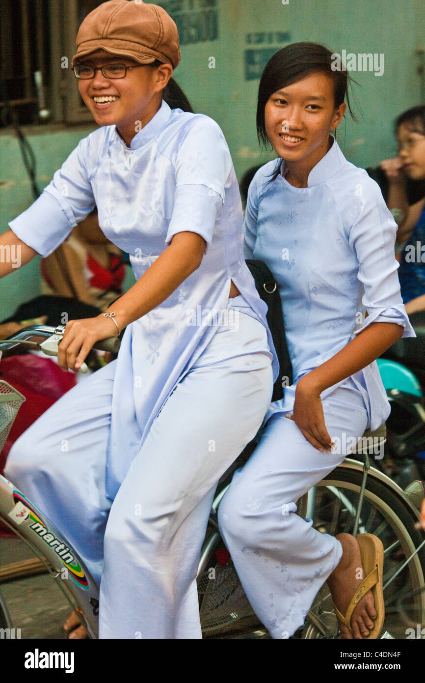 https://c8.alamy.com/comp/C4DN4F/two-students-in-ao-dai-dress-on-bicycle-C4DN4F.jpg