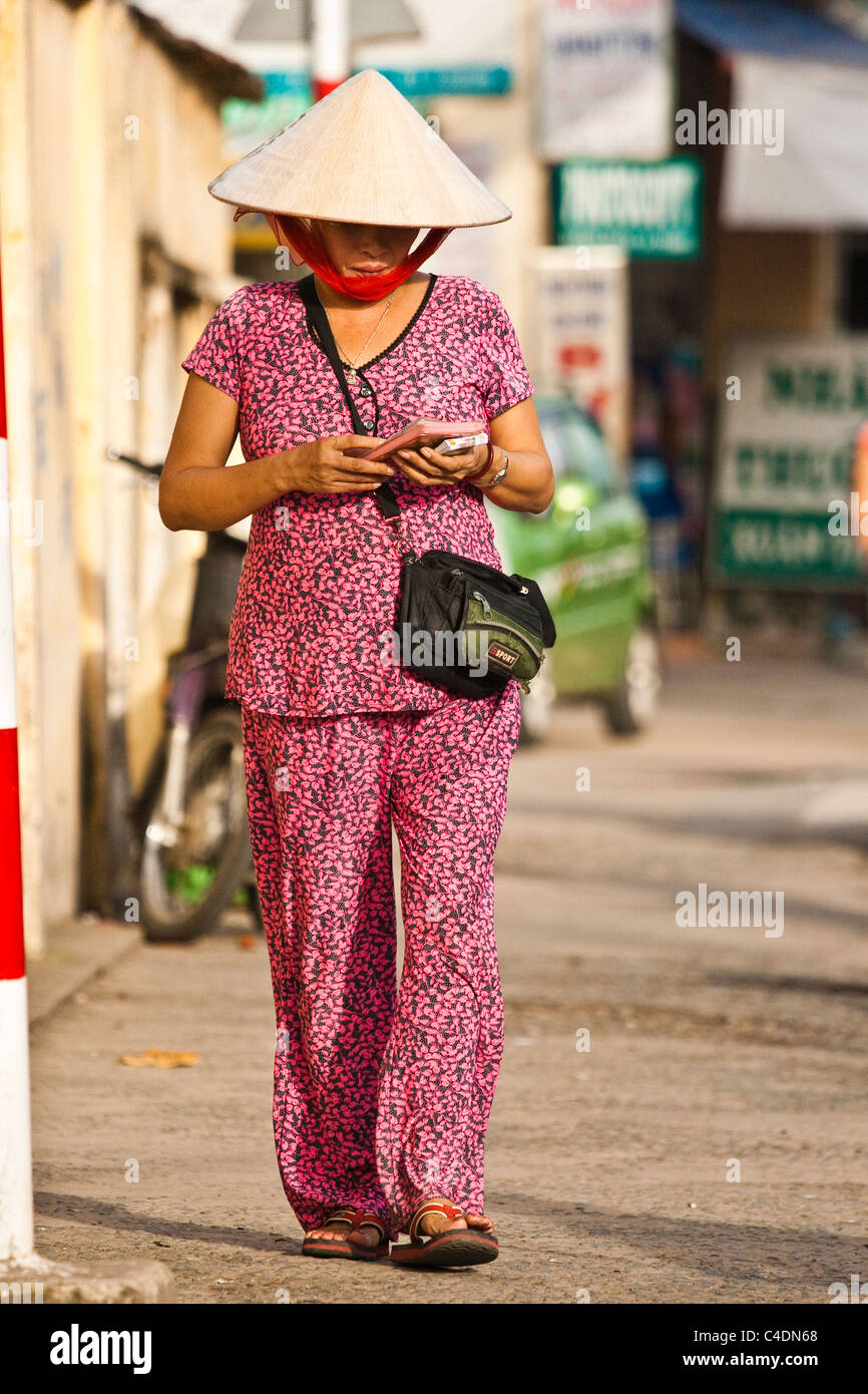 Woman wearing conical hat selling lottery tickets Stock Photo