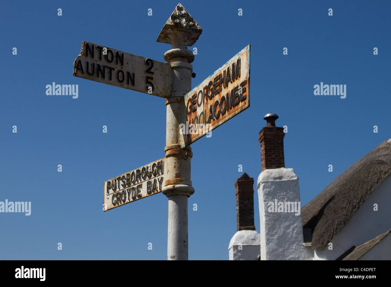 Georgeham, Woolacombe, Taunton, Croyde Bay. Old UK signpost, metal street sign for different destinations. Thatched Cottage in North Devon, UK Stock Photo