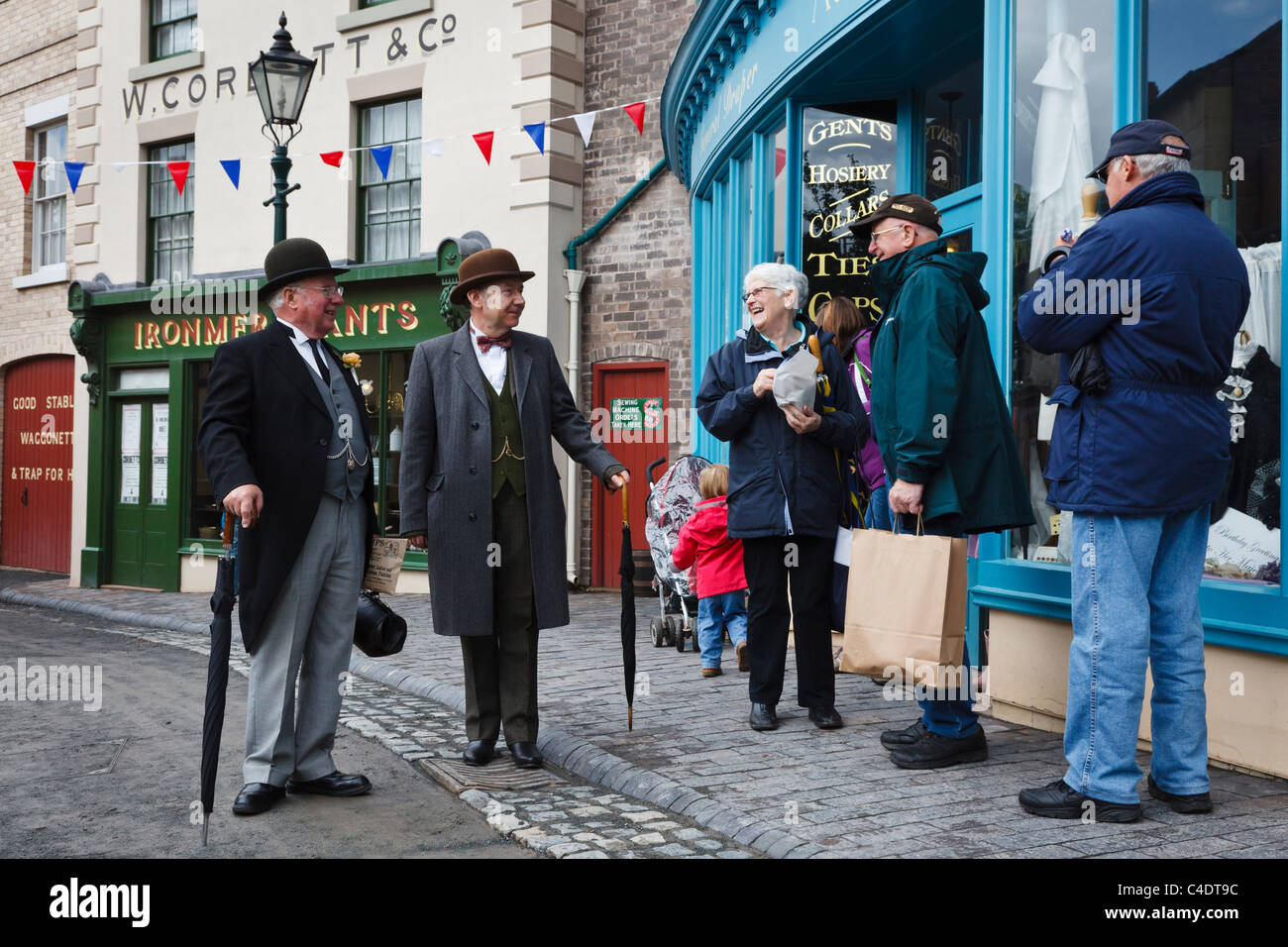 Visitors to Blists Hill Victorian Town in Ironbridge chat to characters in period costume. Stock Photo