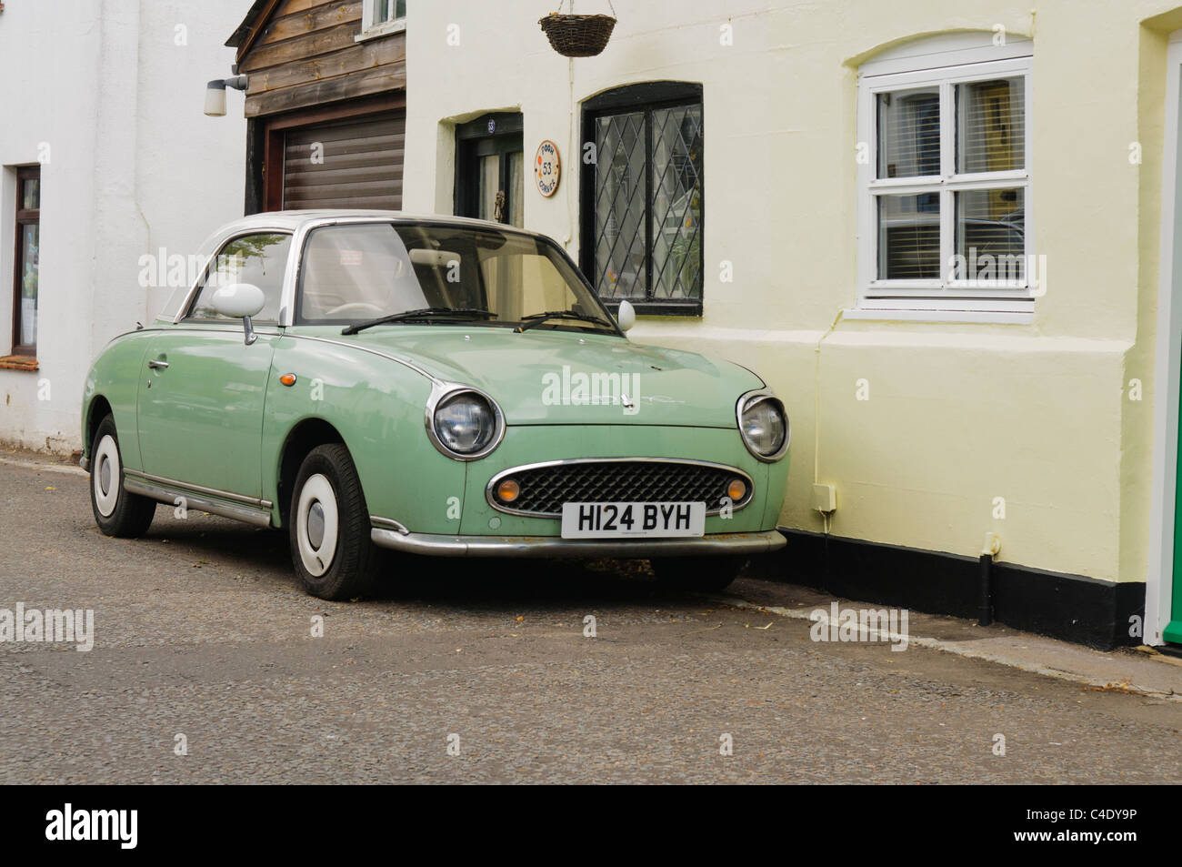 Nissan Figaro parked beside a house Stock Photo