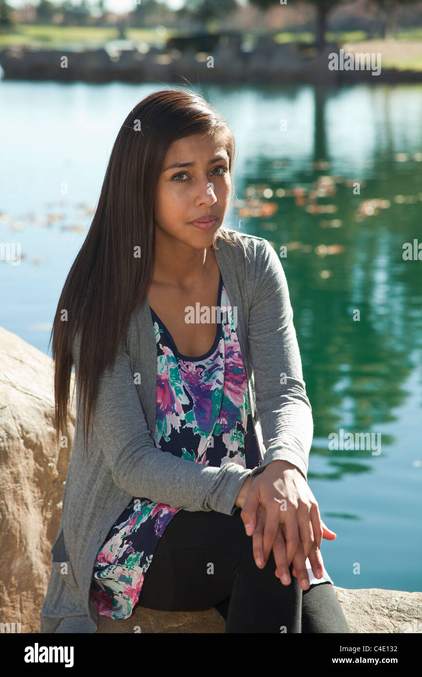 Hispanic teen girl sitting in nature serious thinking thoughtful dreaming sitting thoughtful dreaming sitting seriously meditating MR   © Myrleen Pearson Stock Photo