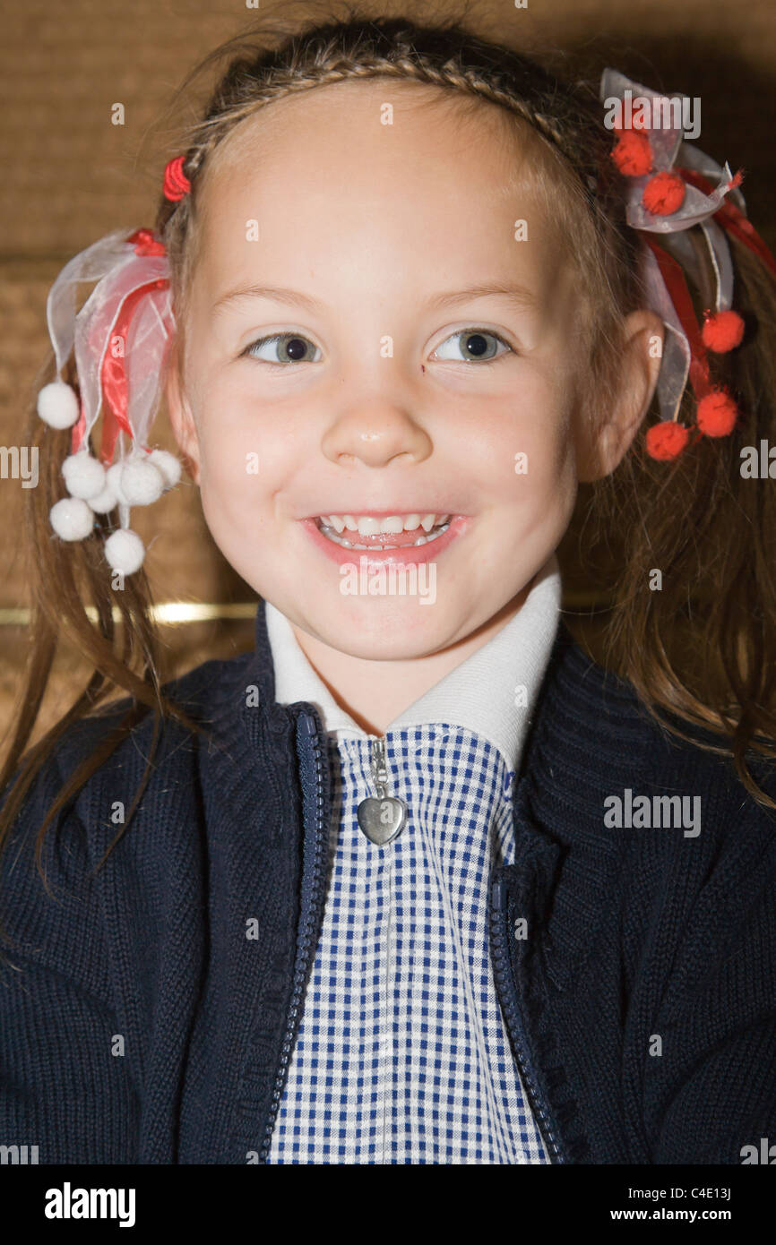 4 years old schoolgirl in gingham dress, summer school uniform Stock Photo